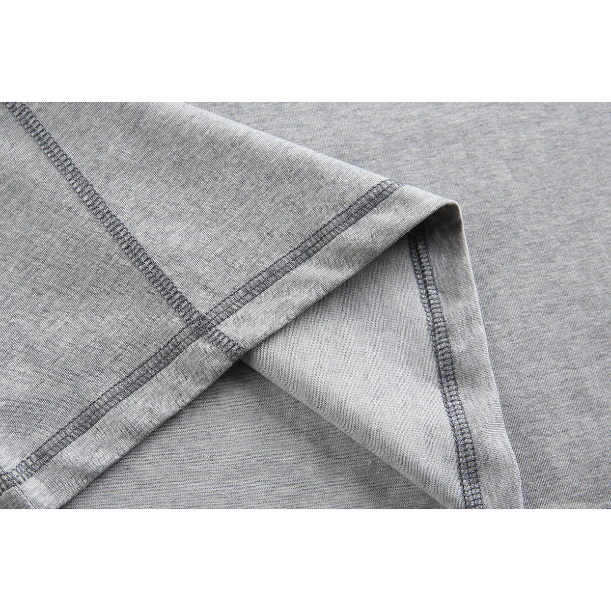 Close-up of gray knit fabric showing dark contrast stitching along a folded seam.