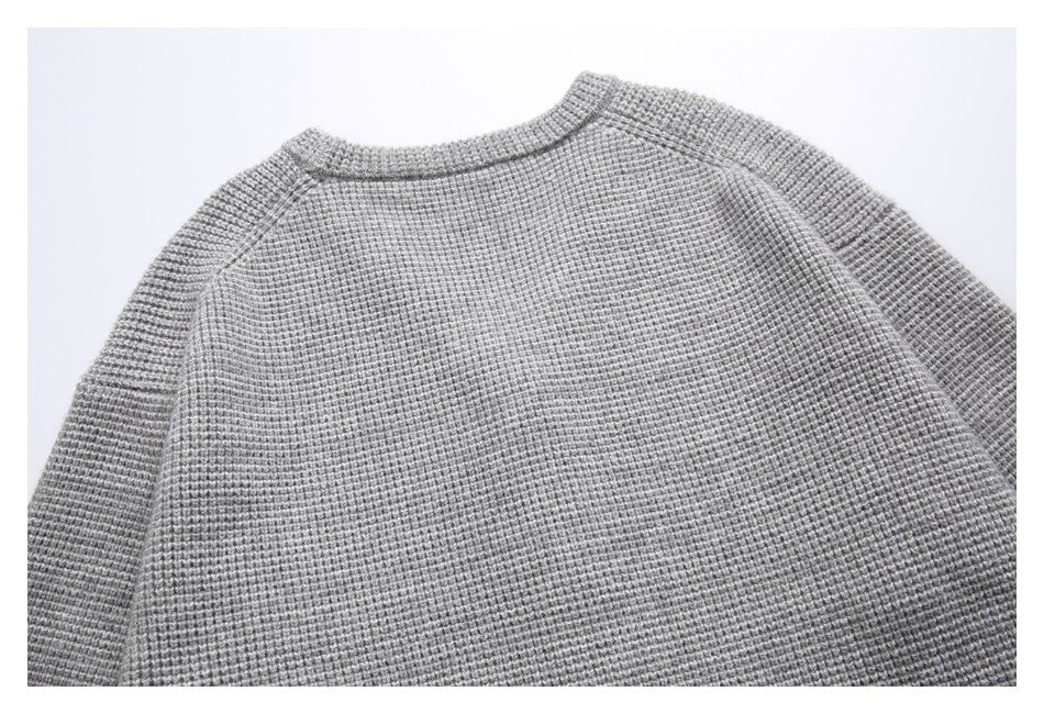 Back view of a gray textured cardigan with a ribbed neckline and raglan sleeves.