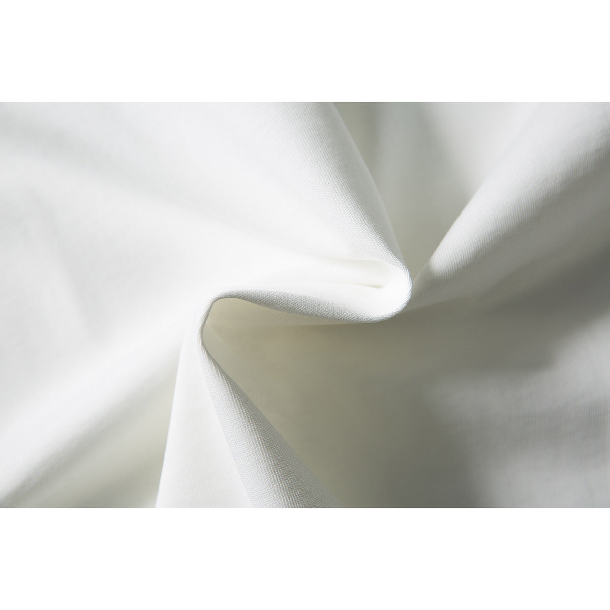 Close-up of softly folded white fabric showing its fine woven texture.