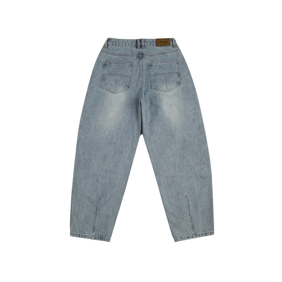 Back view of light-blue washed jeans showing two patch pockets, a brown waistband patch and hem slits
