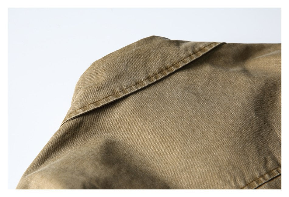 Close-up of a pointed collar and shoulder seam on a khaki-brown garment.