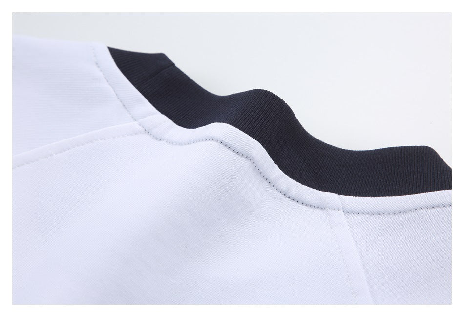 Close-up of a white garment's black ribbed collar and curved neckline stitching.