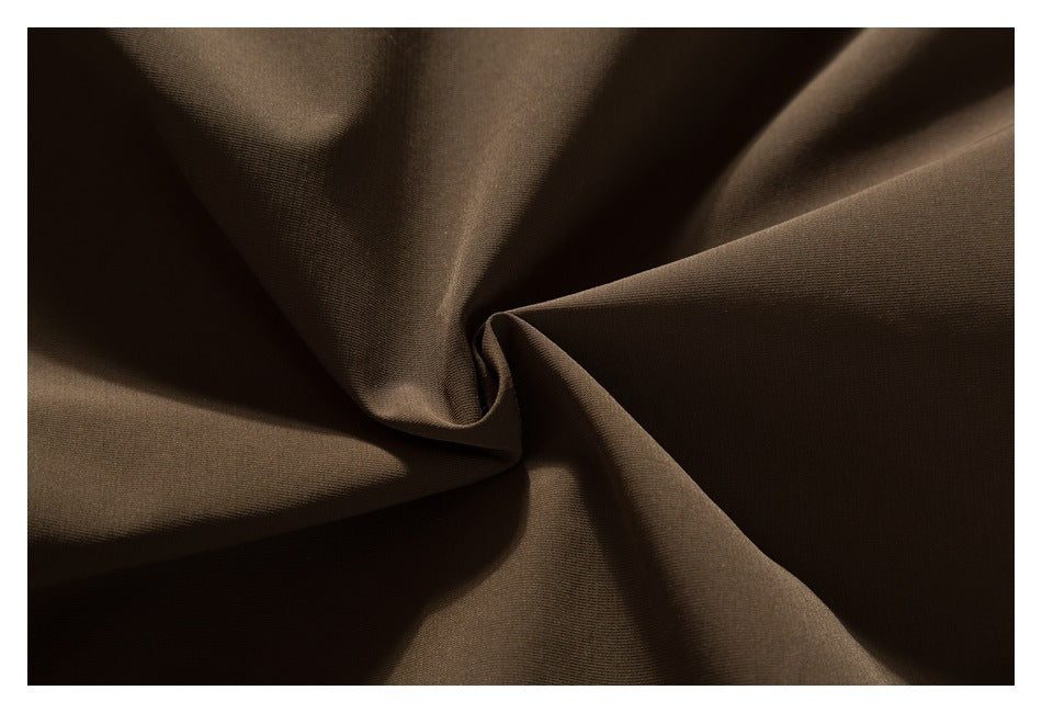 Close-up of dark brown fabric gathered into soft folds.