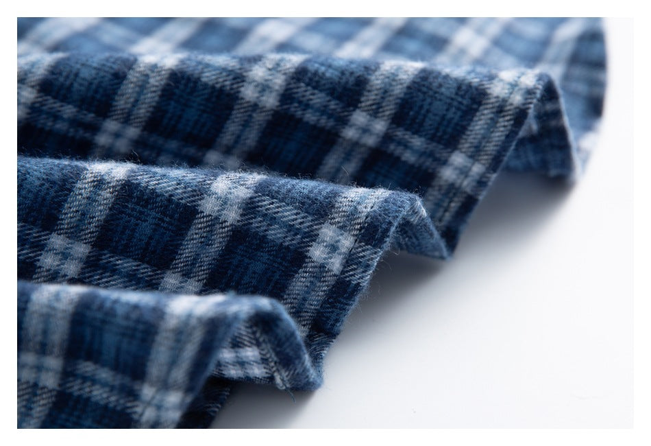 Close-up of folded navy and gray plaid fabric showing its woven pattern and fuzzy texture.