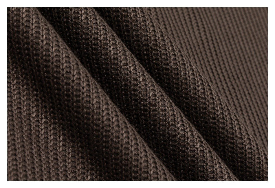 Close-up of dark brown knit fabric showing its textured stitch pattern.