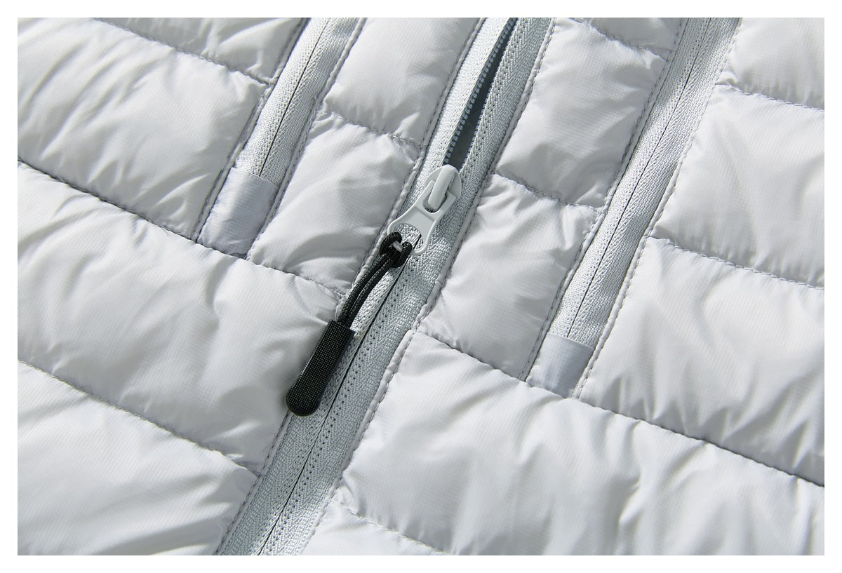 Close-up of the light gray jacket's front zipper, pull cord, and horizontal quilted sections.