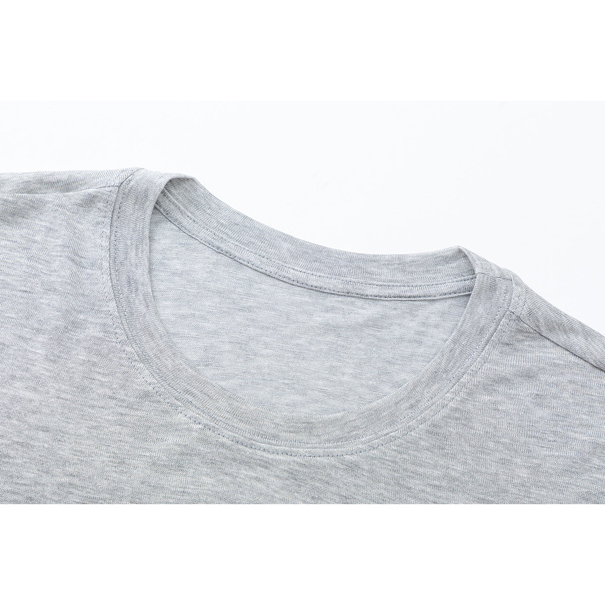 Close-up of a light gray heather long-sleeve shirt's crew neckline and shoulder stitching.