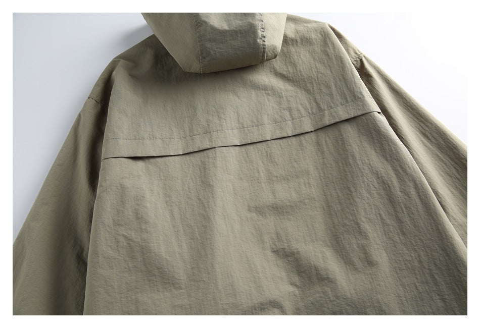 Close-up of the khaki jacket's back with a hood and horizontal back yoke seam.