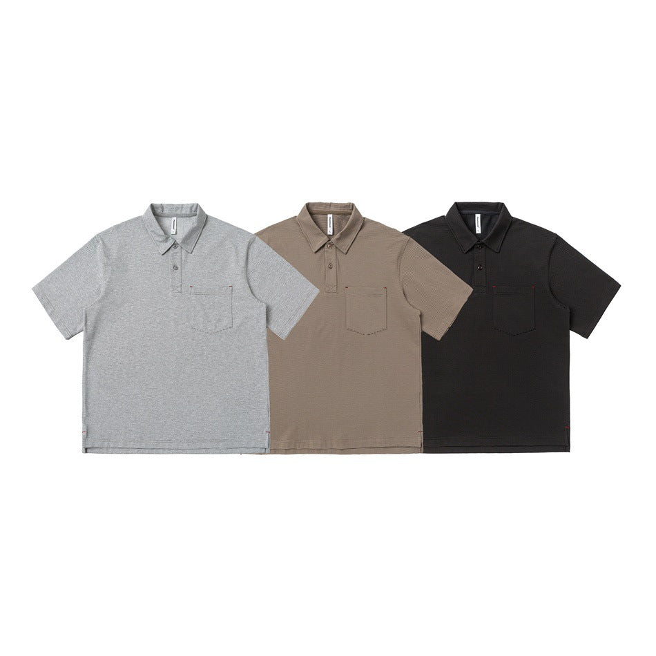 Three short-sleeve collared polo shirts with chest pockets, shown in light gray, taupe, and black.