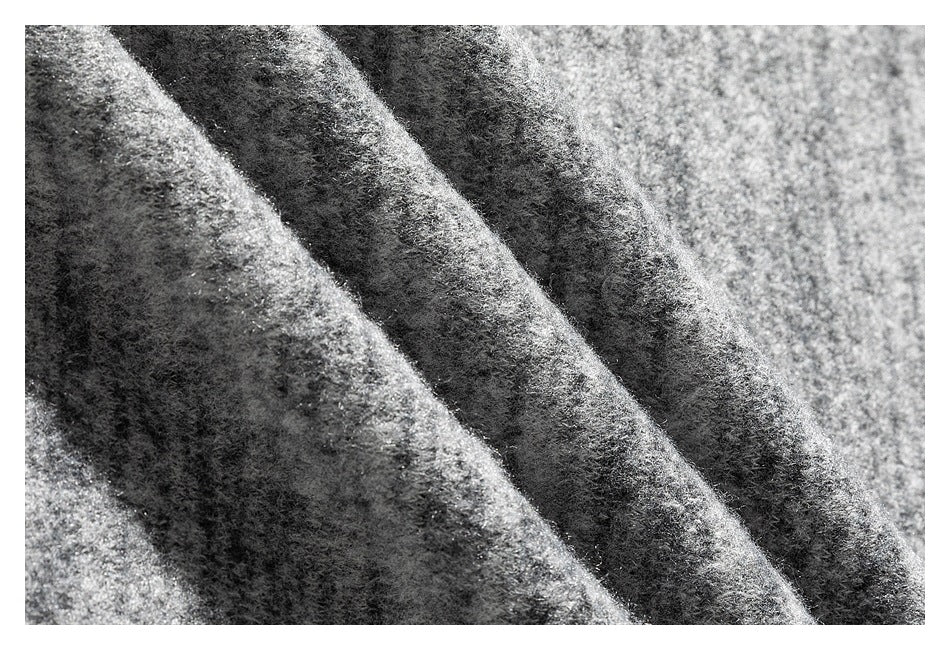 Macro view of the gray shirt's soft-looking marled surface and folded fabric texture.