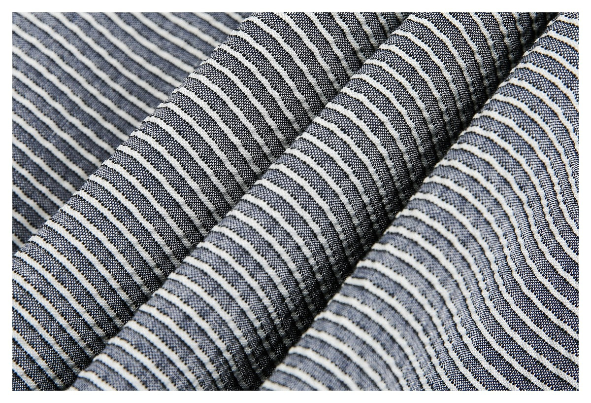 Close-up of folded navy and white striped fabric showing its woven texture.