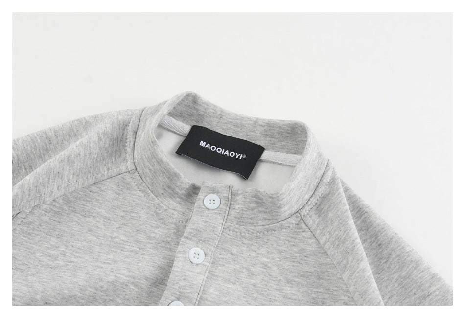Close-up of a heather gray shirt's band collar, white-button placket, and neck label.