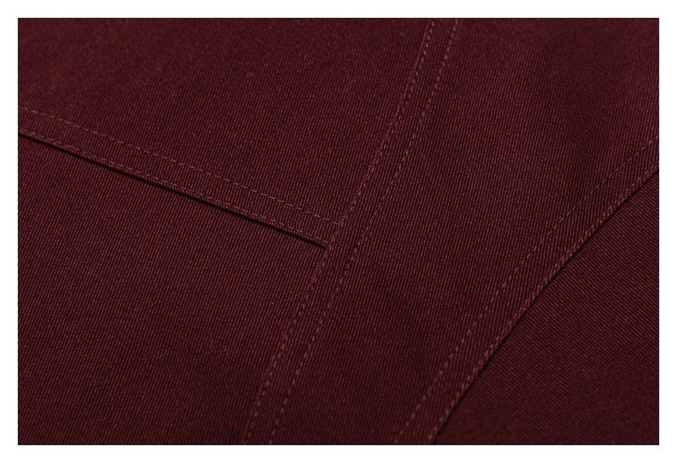 Close-up of deep burgundy jacket fabric with intersecting stitched seams.