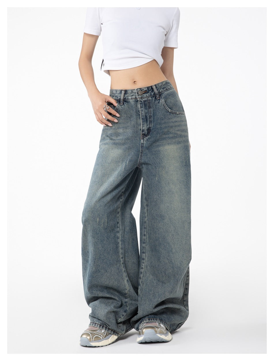 Angled front view of a model wearing faded blue wide-leg jeans and a white cropped T-shirt.