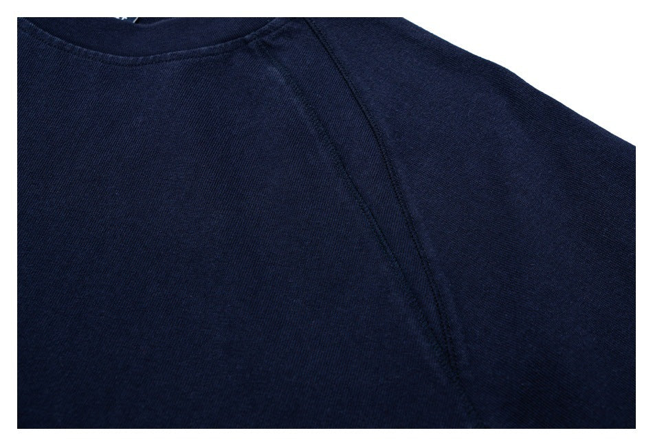 Close-up of the navy shirt's raglan shoulder seam and crew neckline.