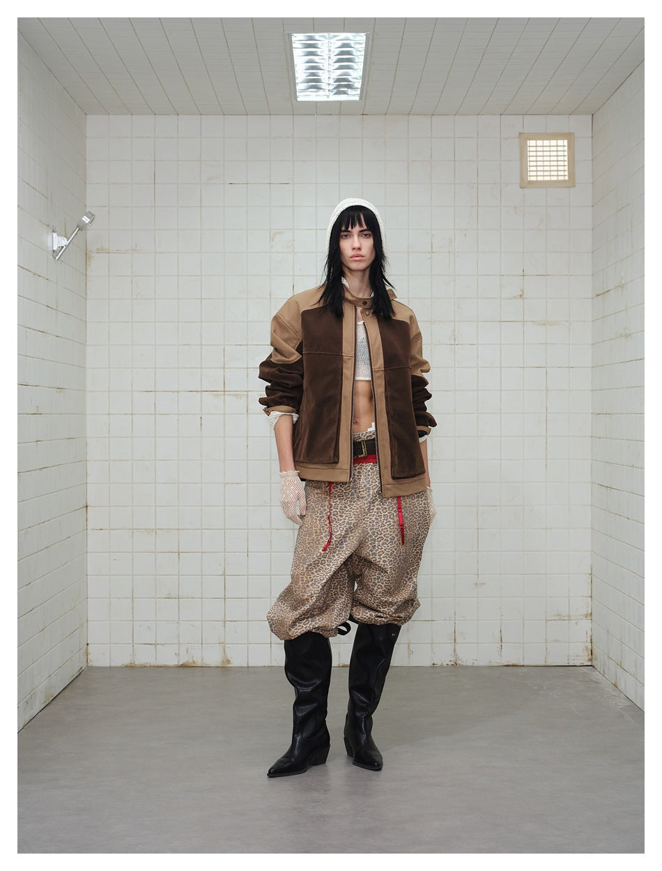Model wearing the brown and tan color-block zip jacket open, with leopard trousers and black boots