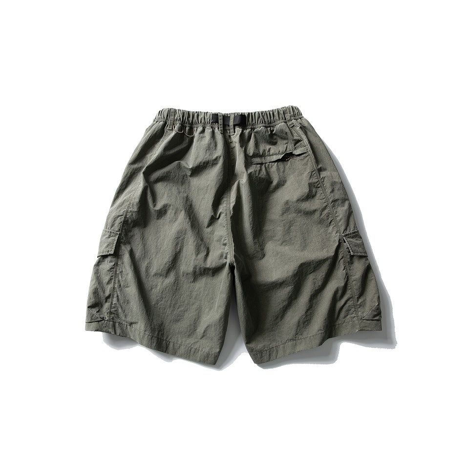 Rear view of olive-gray cargo shorts with an elastic waist, black webbing belt, and side flap pockets.