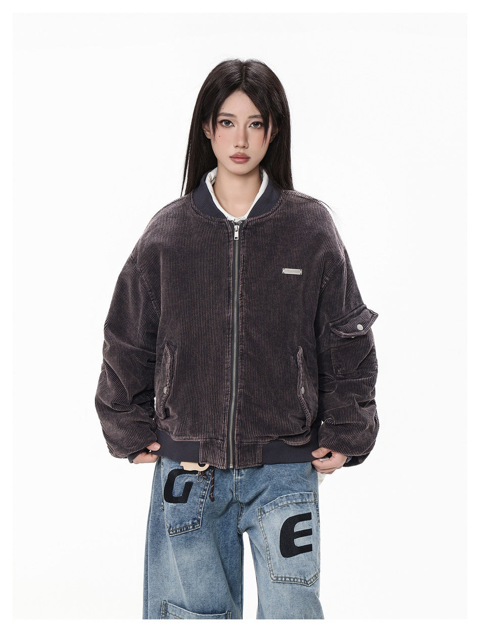 Closer view of a model wearing a dark brown ribbed zip bomber jacket with roomy sleeves and flap details.