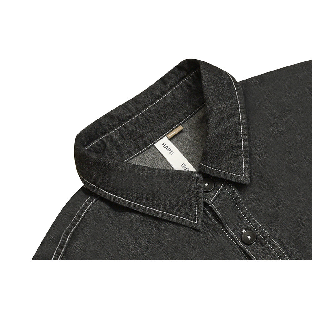 Close-up of a charcoal shirt collar, inner label, dark button, and contrasting white stitching.