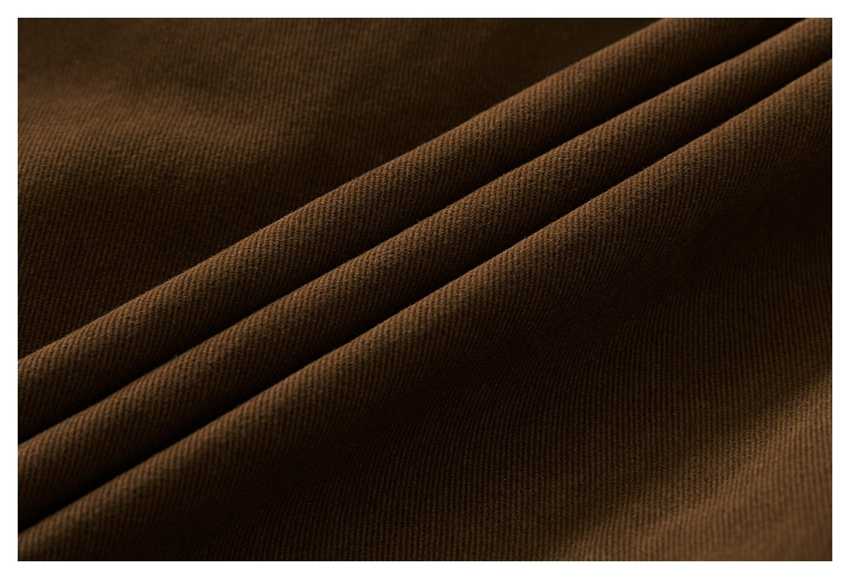 Extreme close-up of dark brown jacket fabric arranged in soft diagonal folds.