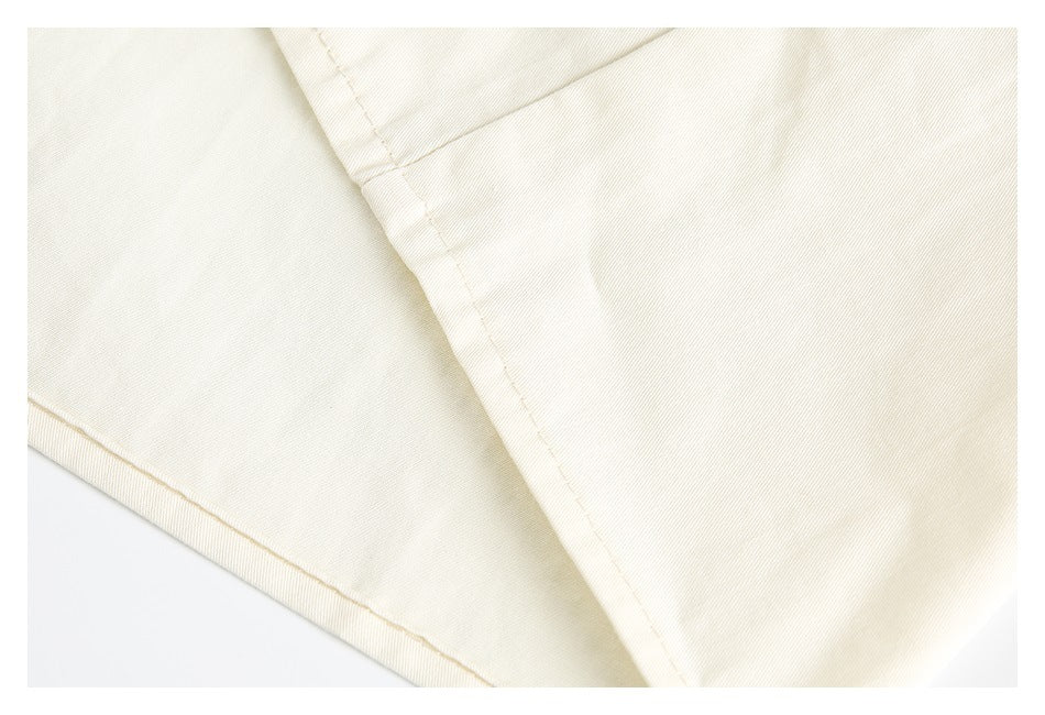 Close-up of the ivory shirt's fabric and stitched seam.