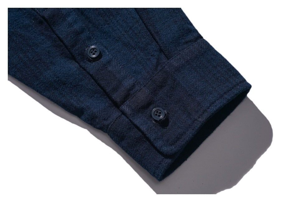 Close-up of the dark navy shirt cuff with two buttons.