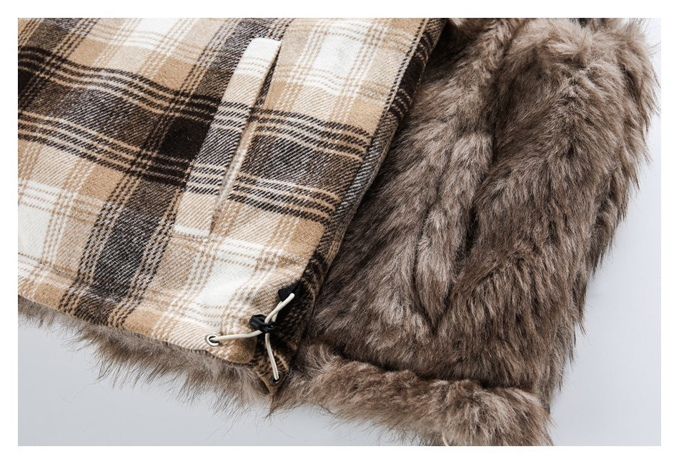 Close-up of a brown faux-fur garment with beige plaid lining, an adjustable drawcord and toggle at the edge.