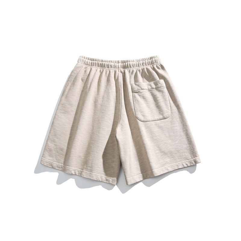 Light beige shorts shown from the back, with an elastic waistband and a single patch pocket.