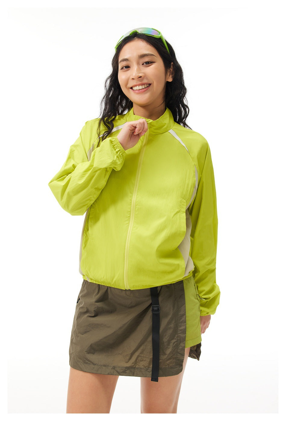 Waist-up view of a woman wearing a lime-green zip jacket with light shoulder and side panels.