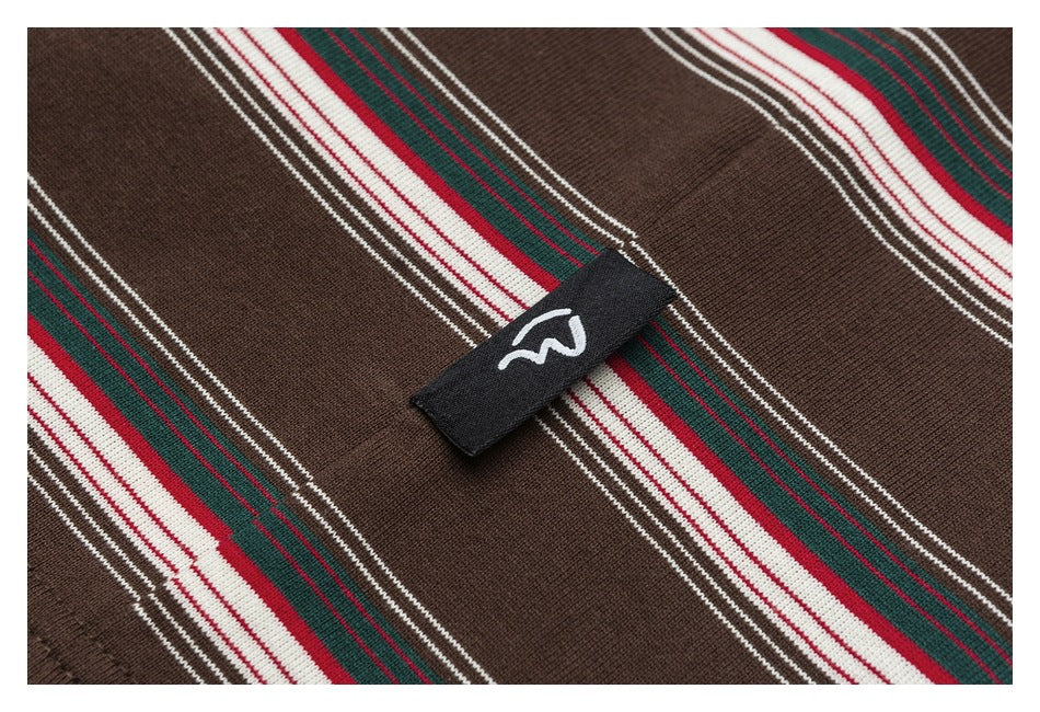 Close-up of brown knit fabric with diagonal red, green and white stripes and a small black logo tab.