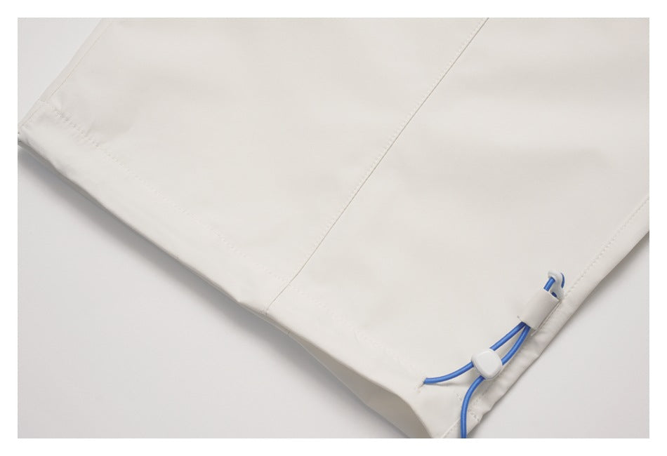 Close-up of a white pant leg hem with a blue drawcord and white adjustment toggles.