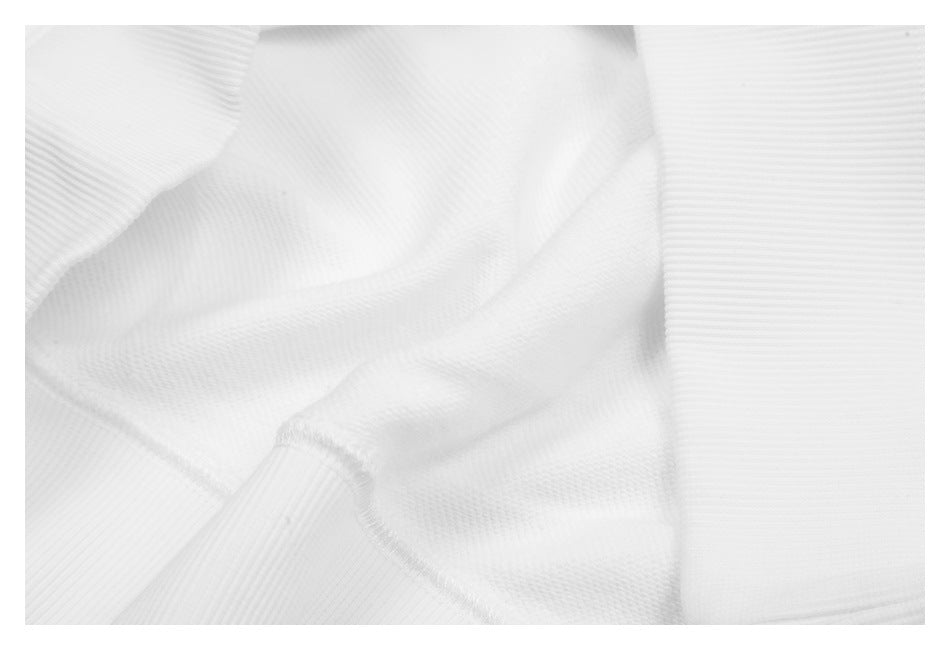 Close-up showing ribbed white fabric, a seam, and a ribbed edge.