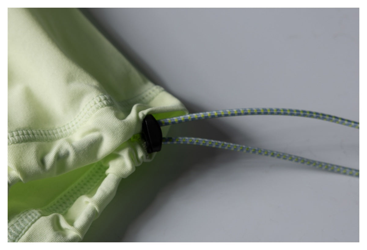 Close-up of the jacket hem's adjustable drawcord, black cord lock, and stitched edge.