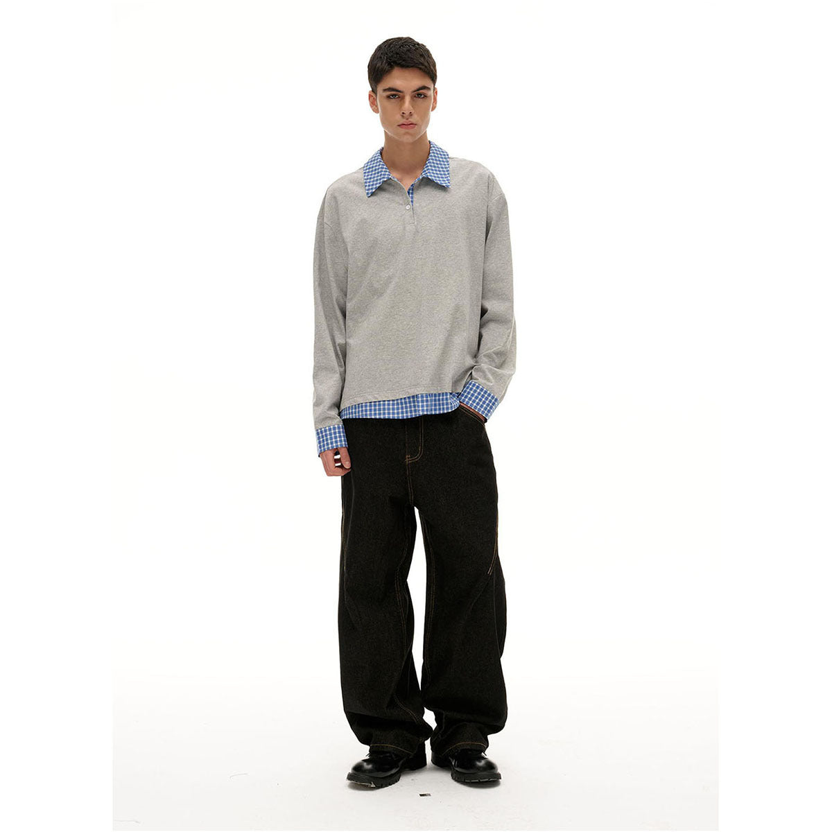 Model wearing a light gray long-sleeve top with blue checked collar, cuffs, and hem, paired with loose black jeans.
