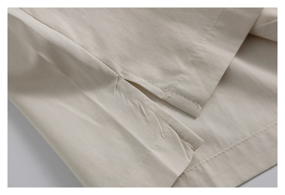 Close-up of stitched seams and a folded opening in pale beige fabric.