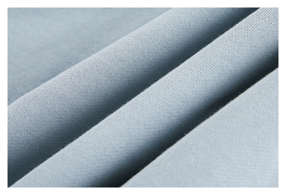 Macro view of pale blue sweatshirt fabric arranged in soft folds.