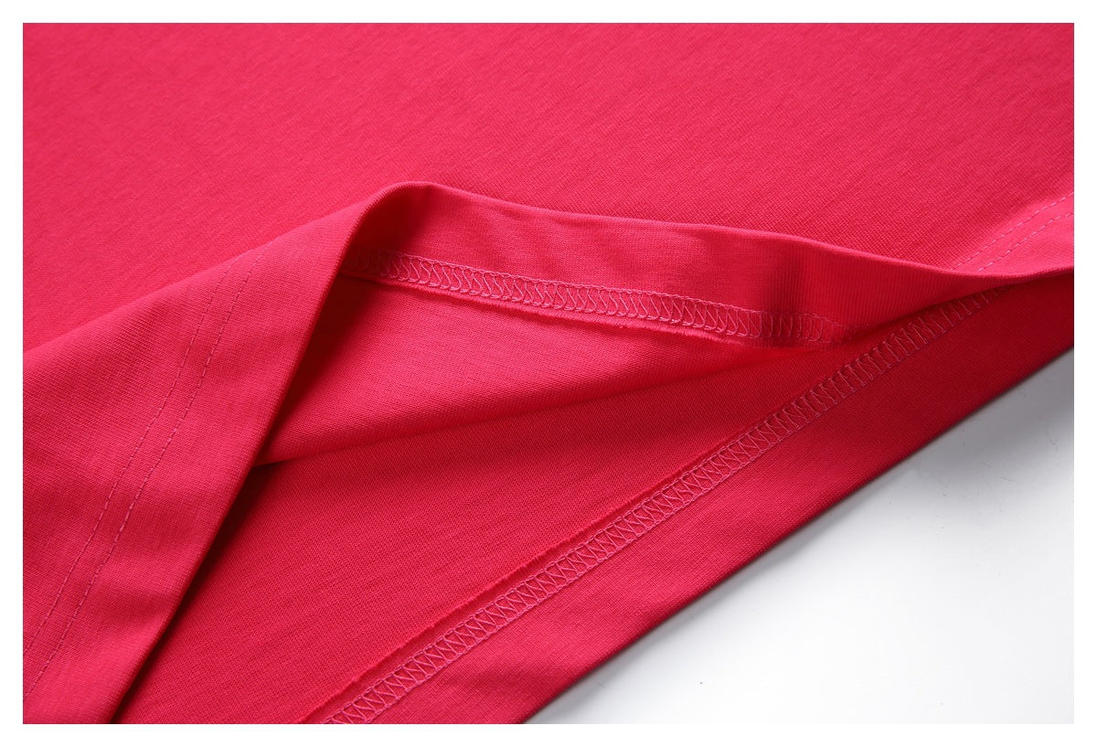 Close-up of the bright pink T-shirt’s folded hem and visible overlock stitching.