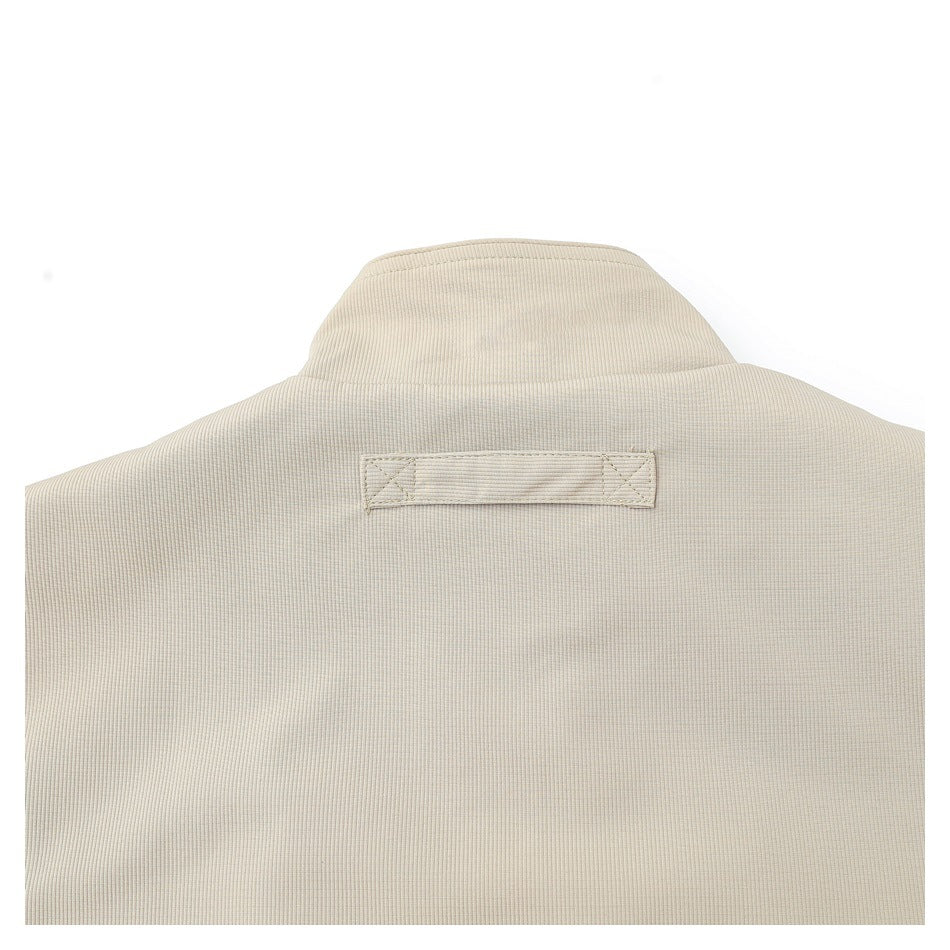 Close-up of the beige jacket's back collar and stitched hanging loop.