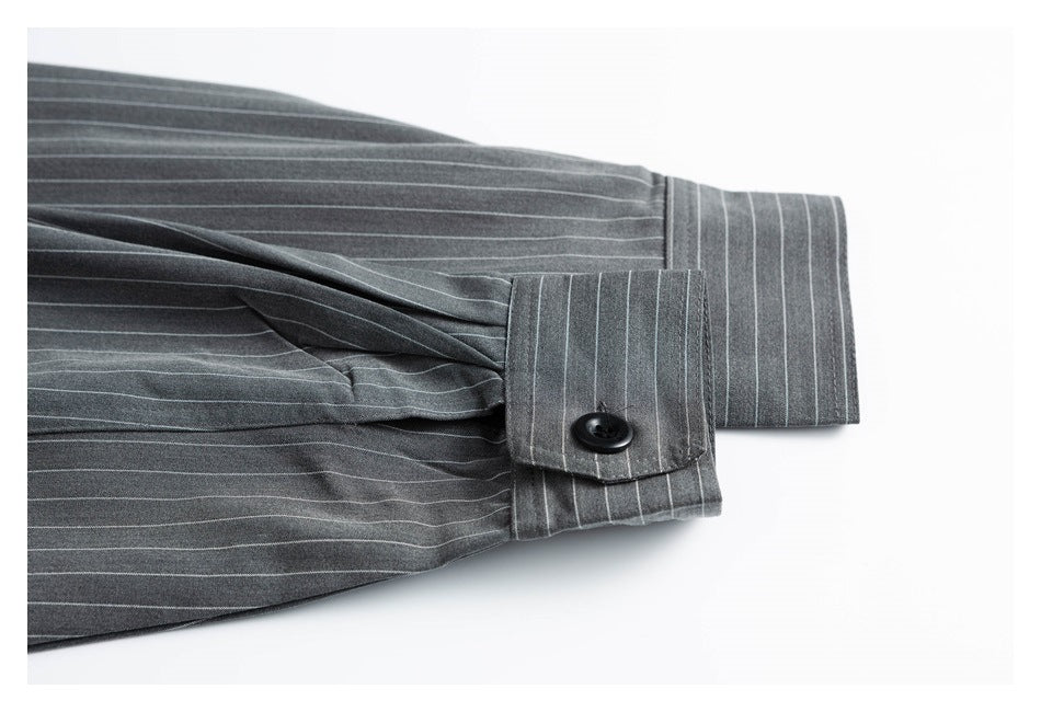 Close-up of a charcoal pinstripe sleeve cuff with a black button and stitched button tab.