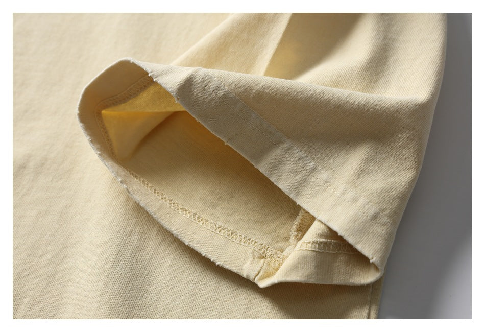Close-up of a pale cream shirt sleeve hem, showing the inner overlock stitching.