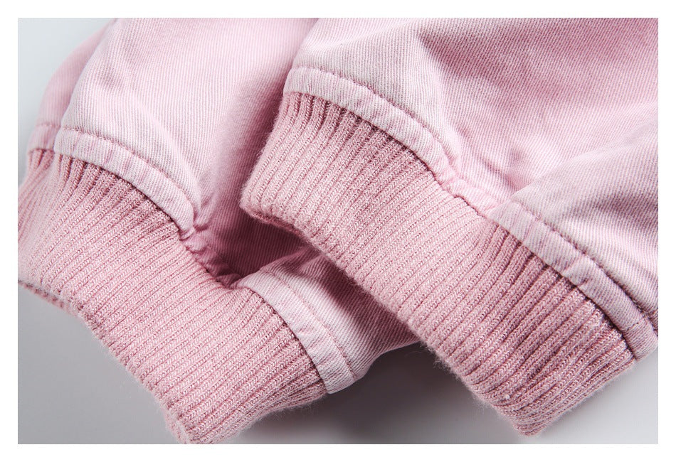 Close-up of pale pink jacket sleeves ending in wide ribbed cuffs.