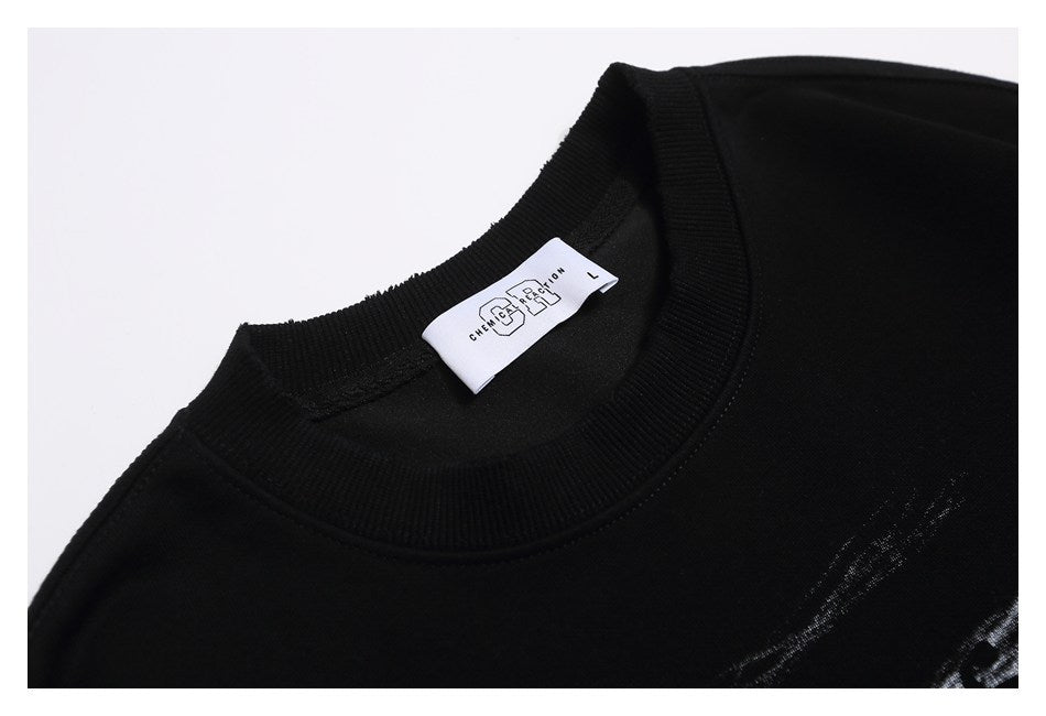 Close-up of a black sweatshirt's ribbed crew neck, white size label and partial pale chest print.