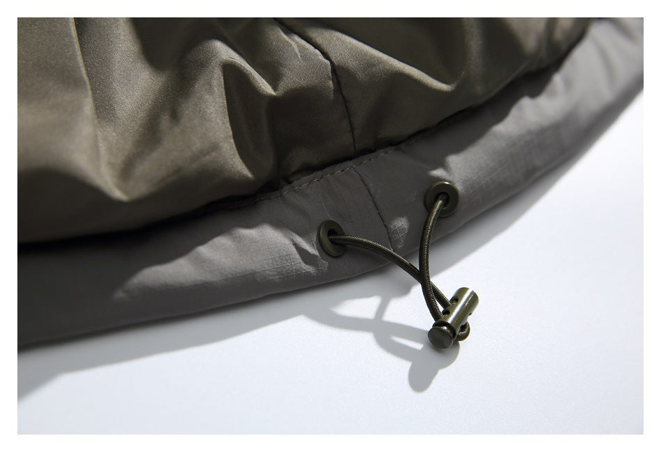 Close-up of a jacket hem with eyelets and an elastic drawcord toggle.