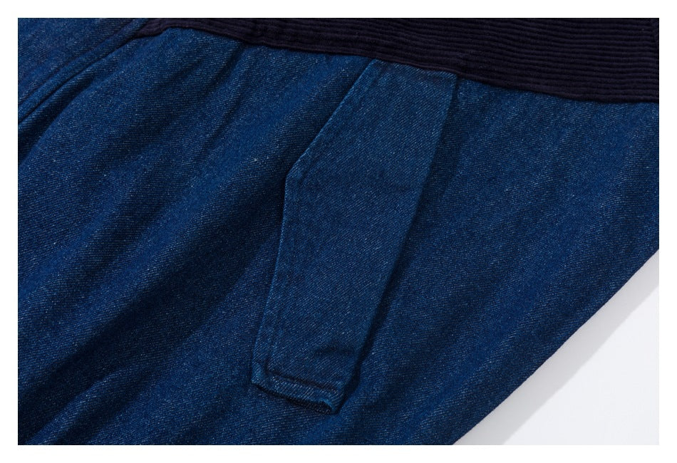Close-up of a narrow denim tab pocket beneath a dark ribbed band.