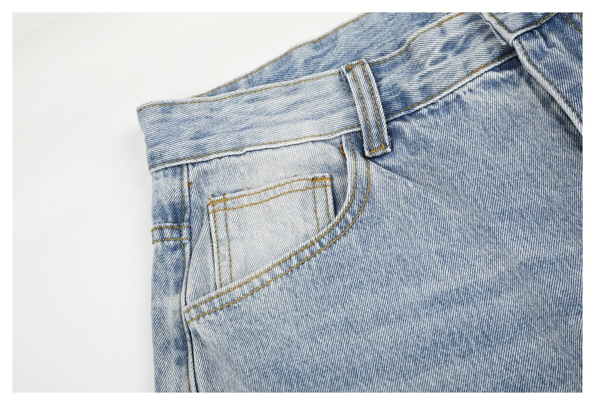Close-up of light blue washed jeans showing a small front pocket, belt loop, and contrast stitching.