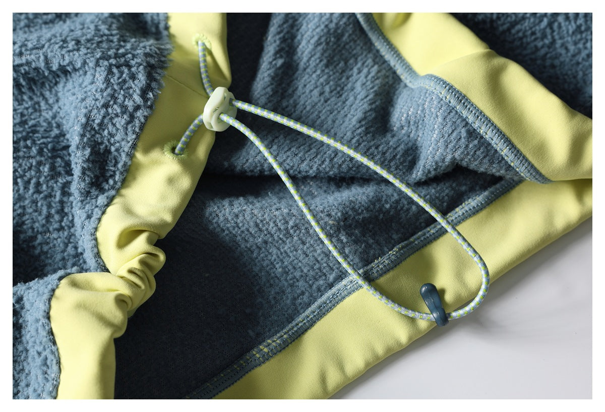 Close-up of the jacket hem's adjustable cord and toggle against blue fleece and yellow-green lining.