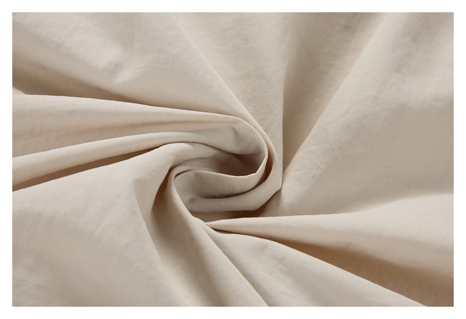 Close-up of cream-colored fabric arranged in folds.