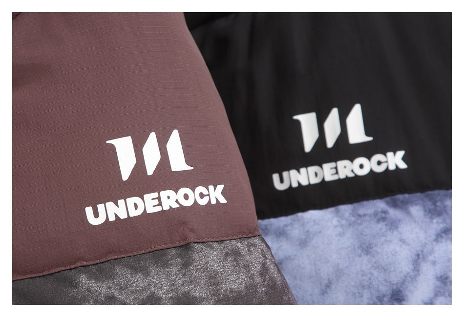 Close-up of brown and black jacket panels with white UNDEROCK logos above blue-gray patterned fabric.