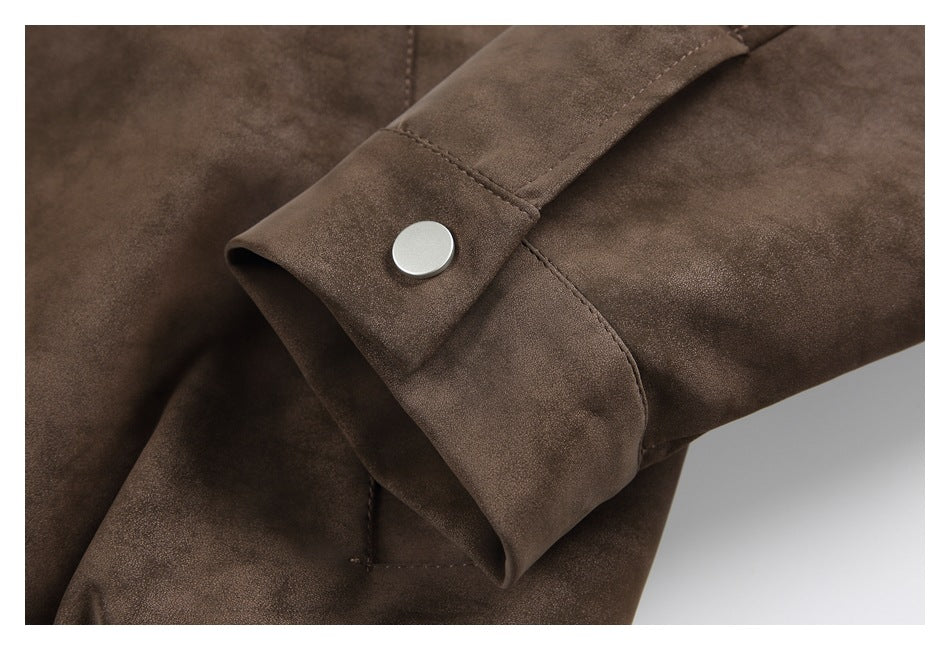 Close-up of a brown jacket sleeve cuff with a round silver snap and visible stitching.