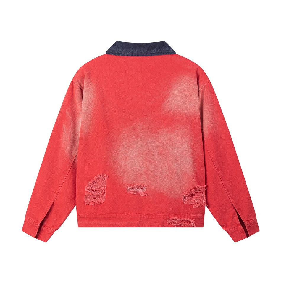 Back of a faded red jacket with a dark blue collar and distressed patches near the hem, shown flat.